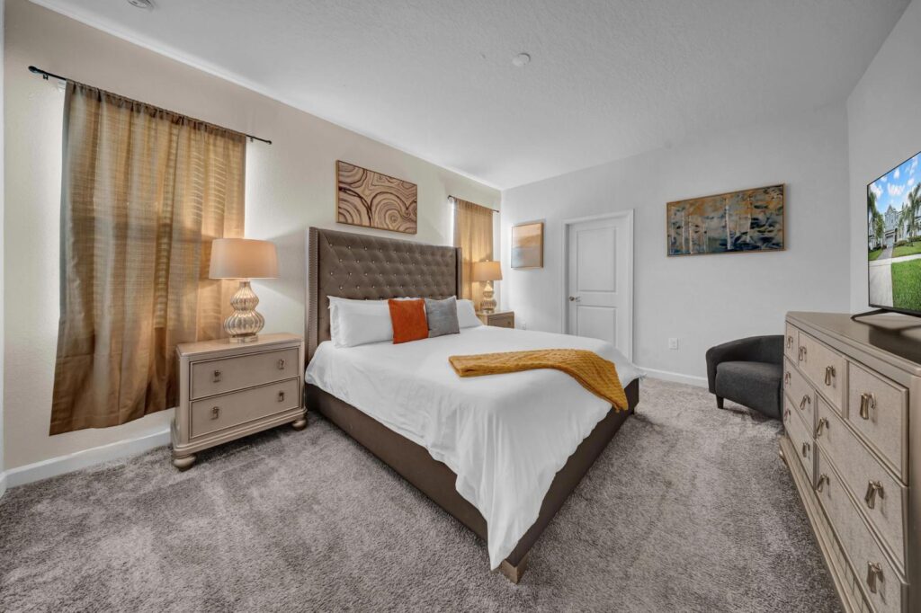 Spacious master bedroom with king-size bed, modern décor, and large windows in vacation villa.